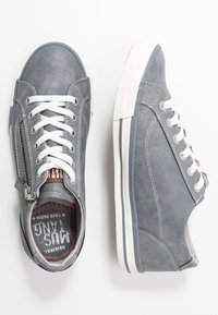 Sneakers in pelle grigia con lacci bianchi, zip laterale, suola in gomma e soletta con dettagli rossi. Presentano dettagli di cucitura e una forma della punta arrotondata.