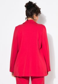 Rode blazer met een getailleerde pasvorm, lange mouwen en een gladde textuur. Kenmerkt zich door een klassieke revers en knopelementen op de mouwen.