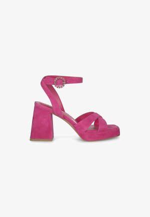 Rosa Wildledersandalen mit Blockabsatz, gekreuzten Riemen an der Vorderseite und einem Knöchelriemen mit einer dekorativen, runden Schnalle.