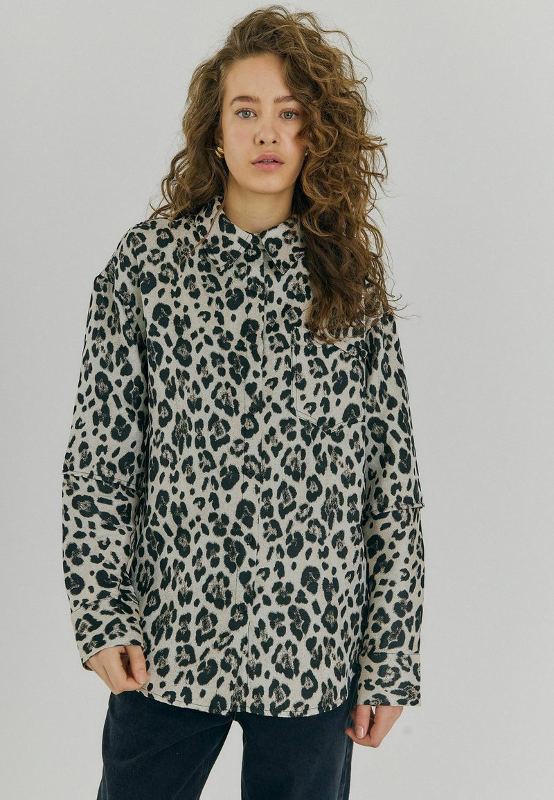 Leopardprint skjorte med knaplukning i lys grå og sort, lange ærmer, afslappet pasform, med en frontlomme og klassisk krave.