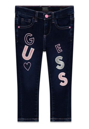 Jean enfant bleu foncé avec des lettres brodées en rose et argent formant le mot "GUESS" et un cœur rose sur les jambes avant.