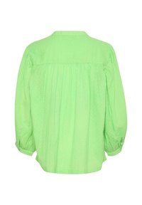 Green polka dot blouse with a gathered back, buttoned cuffs, and a rounded collar. Features long sleeves and textured fabric.