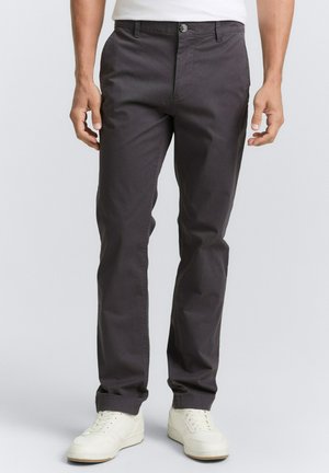 Gray cotton pants with a straight-leg design, featuring belt loops and a single button closure, paired with white sneakers.