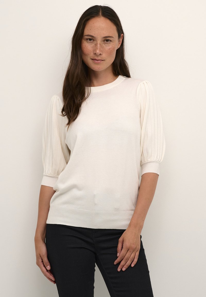 Pull en tricot blanc avec de courtes manches bouffantes côtelées, un col rond et un ourlet ajusté. Texture douce, tissu léger.