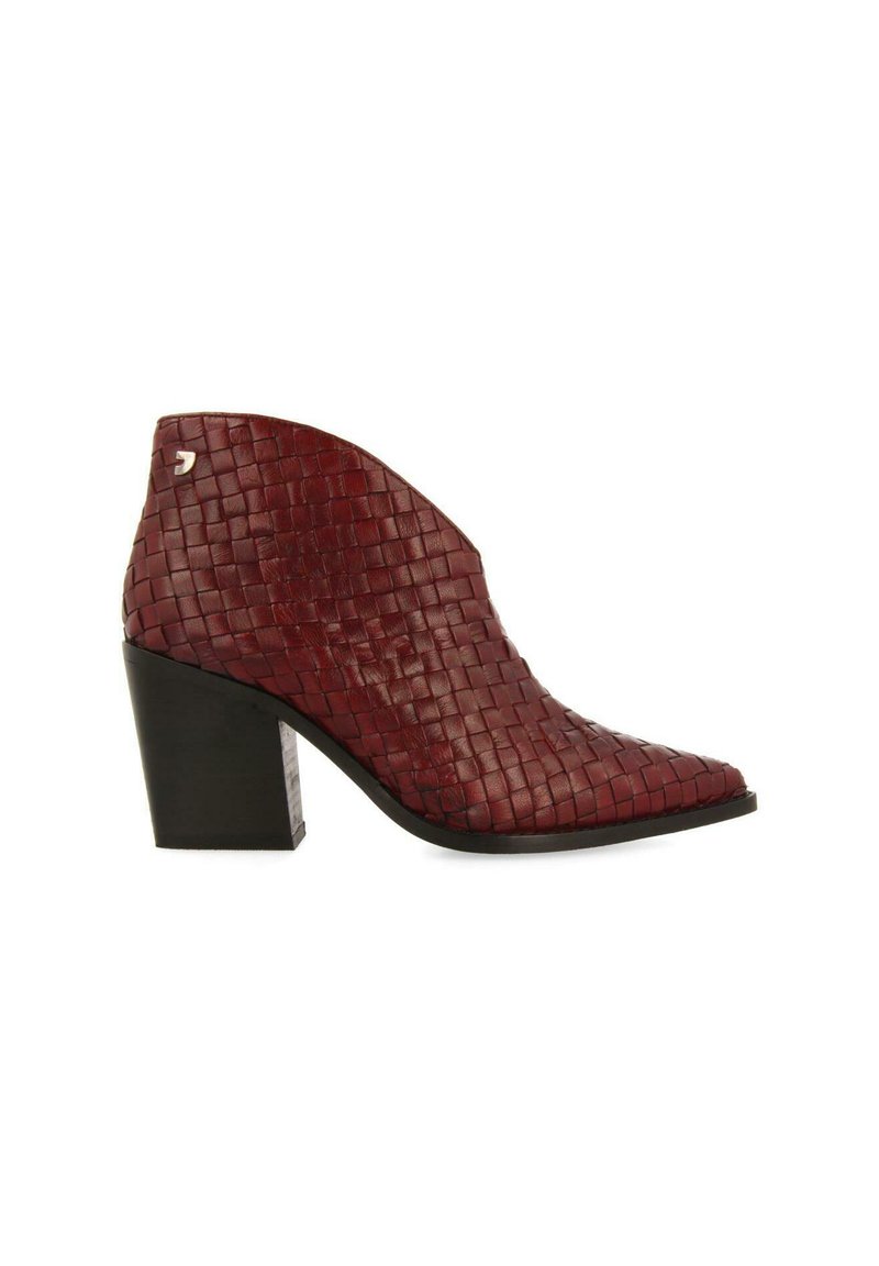 Botas de tobillo de cuero trenzado rojo con punta afilada y tacón cuadrado negro. Patrón texturizado notable en la superficie, con un detalle decorativo en plata.