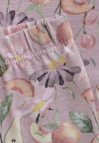Bloemmotief stof in roze tinten, met margrieten, perzik en bladeren. De textuur is glad met een geplooide elastische tailleband.