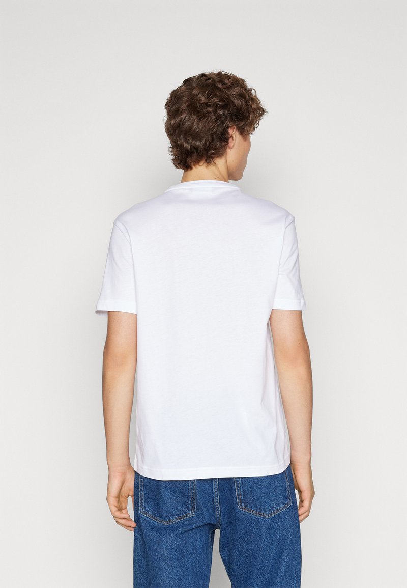 Weißes Baumwoll-T-Shirt mit kurzen Ärmeln, klassischem Rundhals und einem schlichten Design. Abgebildet auf einer Person, die von hinten sichtbar ist, kombiniert mit blauen Jeans.