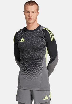 Langärmliges Sportshirt in Schwarz und Grau, mit einem Wellenmuster, limettengrünen Akzenten und drei Streifen auf den Schultern.
