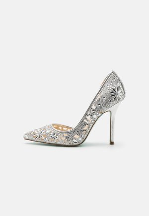 Silver high-heeled pump with lace-like cutouts and floral embellishments, featuring a pointed toe and a shiny metallic heel.