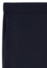 Tissu tricoté bleu marine foncé avec une large taille côtelée, plié soigneusement pour montrer la texture et la qualité du matériau.