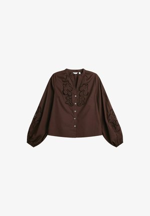 Brun bomuldsbluse med lange pufærmer, en mandarinkrave og indviklet blomstermønsterbroderi på hver side. Fem knapper ned foran.