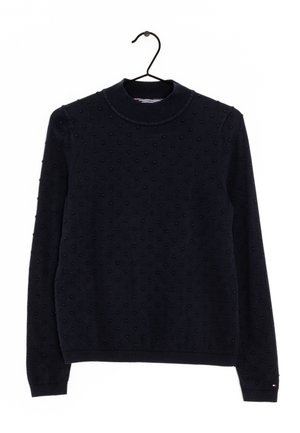 Pull à manches longues bleu marine avec des points texturés, col rond côtelé, poignets et ourlet, accroché à un cintre noir sur un fond blanc.