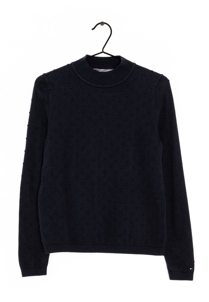 Pull à manches longues bleu marine avec des points texturés, col rond côtelé, poignets et ourlet, accroché à un cintre noir sur un fond blanc.