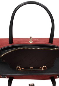Rode suède handtas met zwarte leren accenten en twee handvatten. Binnenkant heeft een zwarte voering, gouden ritssluiting en metalen details.