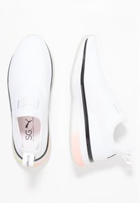 Białe sneakersy slip-on z teksturowaną cholewką, czarnym akcentem przy podeszwie i kolorowym pasem na pięcie. Wyróżniające się logo na wkładce.