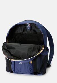 Marineblauwe rugzak met een grote opening, zwarte binnenvoering, mesh vak, verstelbare schouderbanden en een voorvak met ritssluiting en multi-kleurige accenten.