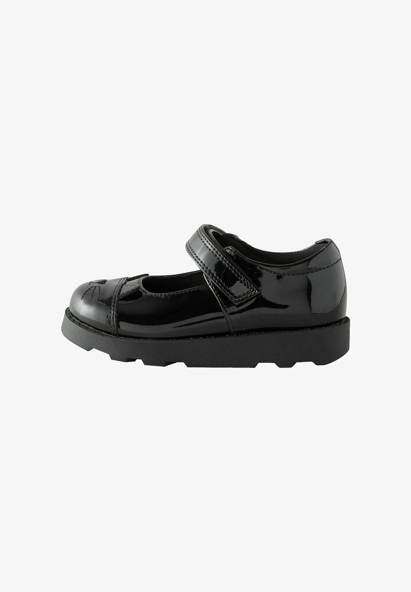 Chaussure Mary Jane en cuir verni noir avec bride Velcro et détails découpés, dotée d'une semelle épaisse et texturée.