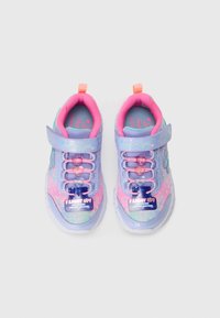 Sneakers luminosi viola e rosa con un cinturino in velcro, lacci a forma di cuore e un motivo glitterato su una superficie testurizzata.