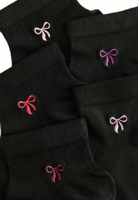 Zwarte sokken met kleine geborduurde strikken in roze, paars en rood, met ribgebreide manchetten en een gladde textuur.