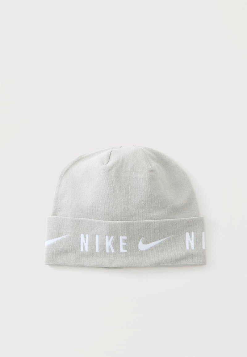 Bonnet Nike gris clair avec texte Nike blanc et logos swoosh autour du bord replié, affiché sur un fond uni.
