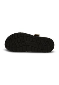 Black rubber shoe sole with a textured tread pattern featuring deep grooves for traction. Includes a small brown tab near the heel.