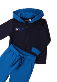 Sudadera azul marino con capucha forrada en azul y gráfico de "SOCCER CLUB". Combinada con pantalones jogger azules a juego, que cuentan con una cinturilla elástica.