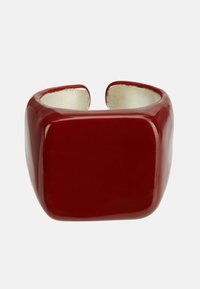 Crvena keramička narukvica s širokim kvadratnim dizajnom i sjajnim završetkom. Unutrašnjost ima glatki metalni izgled s otvorenim krajevima.