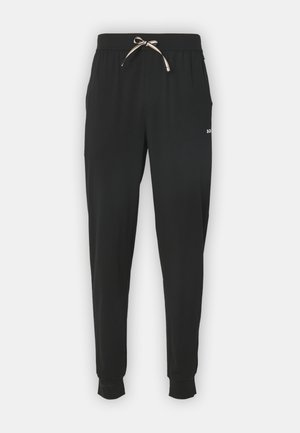 Pantalon de jogging noir en tissu doux. Comprend une taille avec cordon de serrage réglable, des poches latérales et des poignets élastiques aux chevilles.