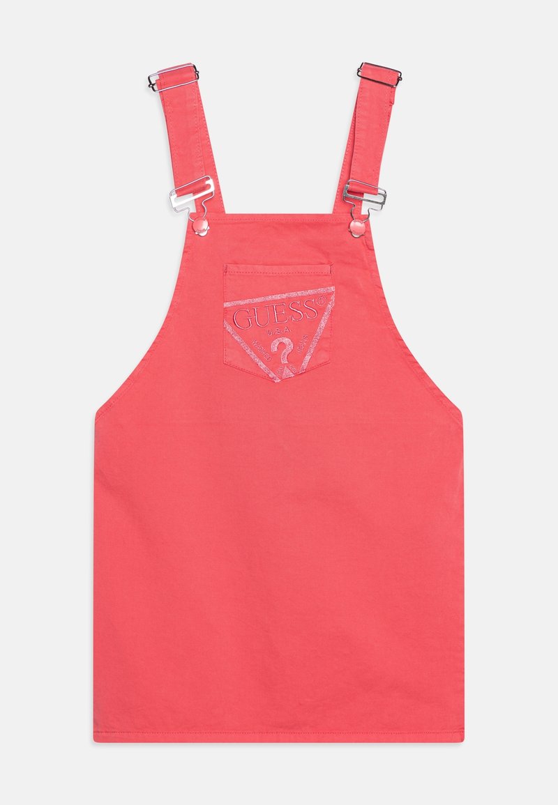 Robe salopette sans manches couleur corail rose avec bretelles réglables et une poche avant présentant un logo GUESS brodé et un motif de point d'interrogation.
