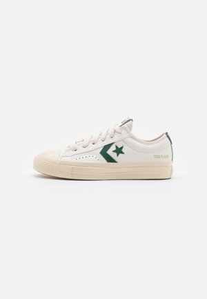 Baskets en cuir blanc avec logo étoile vert, lacets roses et semelle en caoutchouc crème. Dotées de panneaux latéraux perforés et d'un logo sur le talon.