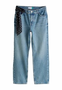 Svetlomodré džínsové nohavice s priamym strihom, zdobené čiernou šatkou s bodkami, priviazanou na páse. Viditeľná je opotrebovaná textúra.