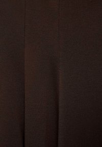 Tissu côtelé brun foncé avec des lignes verticales mettant en valeur la texture tricotée et des variations subtiles de couleur.