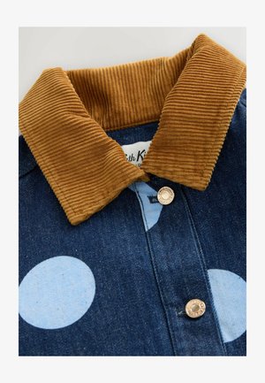 Ciemnoniebieska kurtka dżinsowa z dużymi jasnoniebieskimi groszkami, brązowym kołnierzem z sztruksu i metalowymi zatrzaskami.