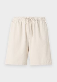 Helle beigefarbene Rippshorts mit elastischem Bund und Kordelzug. Mit seitlichen Taschen und lockerer Passform. Material aus Baumwollmischung.