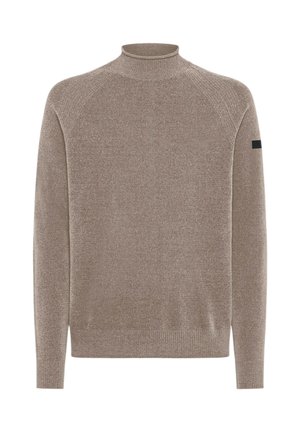 Maglione a maniche lunghe beige-marrone lavorato a maglia con collo alto, polsini e orlo a costine, che mostra una piccola toppa nera sulla manica sinistra.