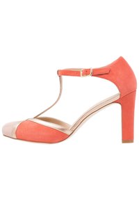 Korálově růžová semišová lodička na vysokém podpatku s T-páskem, kovovými detailem u špičky a béžovou krytkou na špičce. Zvýšený blokový podpatek pro stabilitu.