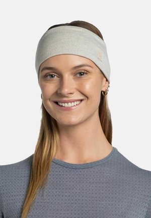 Young woman smiling, wearing light grey fabric headband and grey textured top, with long straight hair and small gold hoop earrings.