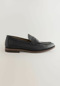 Crni kožni loafer s glatkom završnom obradom, zaobljenim vrhom i ojačanim detaljima na prednjem dijelu. Ima tanki smeđi gumeni potplat.