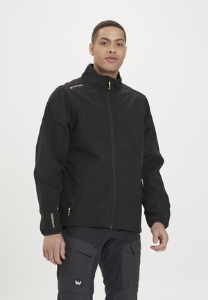 Czarna kurtka typu softshell z wysokim kołnierzem, żółtymi akcentami zamka i dwiema bocznymi kieszeniami. Charakteryzuje się detalami przeszycia, które nadają jej zorganizowany wygląd.