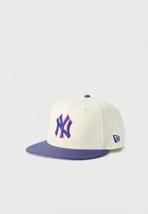 Witte honkbalpet met paarse klep, paarse knop bovenop en blauw NY-logo met roze omlijning op het voorpaneel.