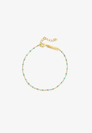 Zlatý náramok s jemným reťazcom, do ktorého sú rozptýlené malé tyrkysové korálky, zakončený zapínaním a gravírovanou značkou.