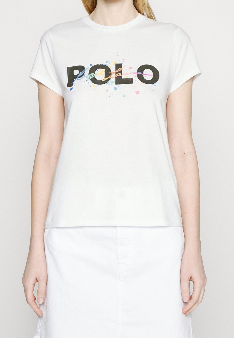 Vit bomull t-shirt med en djärv svart "POLO"-logotyp med färgglada splatter-accenter. Rund halsringning och korta ärmar.