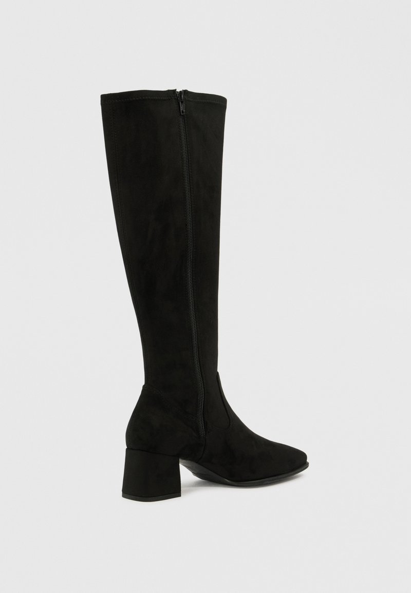 Bota alta de ante negro hasta la rodilla con tacón ancho, puntera afinada y cremallera lateral. Textura suave y silueta sencilla sin patrones visibles.