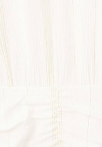 Bílá tkanina s vertikálním zlatým prošitím. Textura vypadá mírně pomačkaně s nařasenými úseky, což vytváří jemný, plynulý vzhled.