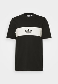 Černé bavlněné tričko s bílým vodorovným pruhem a centrálním logem. Kulatý výstřih a krátké rukávy, jednoduchý design s kontrastními akcenty.