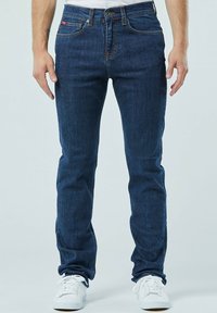 Donkerblauwe jeans in een slim fit, vervaardigd van denim materiaal. Beschikt over een klassieke vijf-pocketontwerp, contrasterende stiksels en een sluiting met een voorknop.