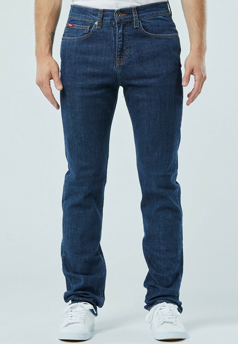 Donkerblauwe jeans in een slim fit, vervaardigd van denim materiaal. Beschikt over een klassieke vijf-pocketontwerp, contrasterende stiksels en een sluiting met een voorknop.