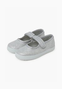 Chaussures Mary Jane en argent pailleté avec une sangle Velcro, bout arrondi et semelle en caoutchouc texturé. Design léger et flexible.