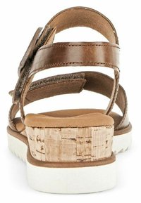Sandale en cuir marron avec plusieurs brides et un talon en liège texturé. Semelle intérieure beige douce et semelle extérieure blanche pour le contraste.