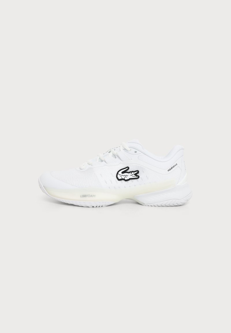 Λευκό sneaker χαμηλού κόψιμου με υφασμένη σόλα, μαύρο κεντημένο λογότυπο κροκοδείλου στο πλάι και σχεδιασμό με κορδόνια σε απλό φόντο.